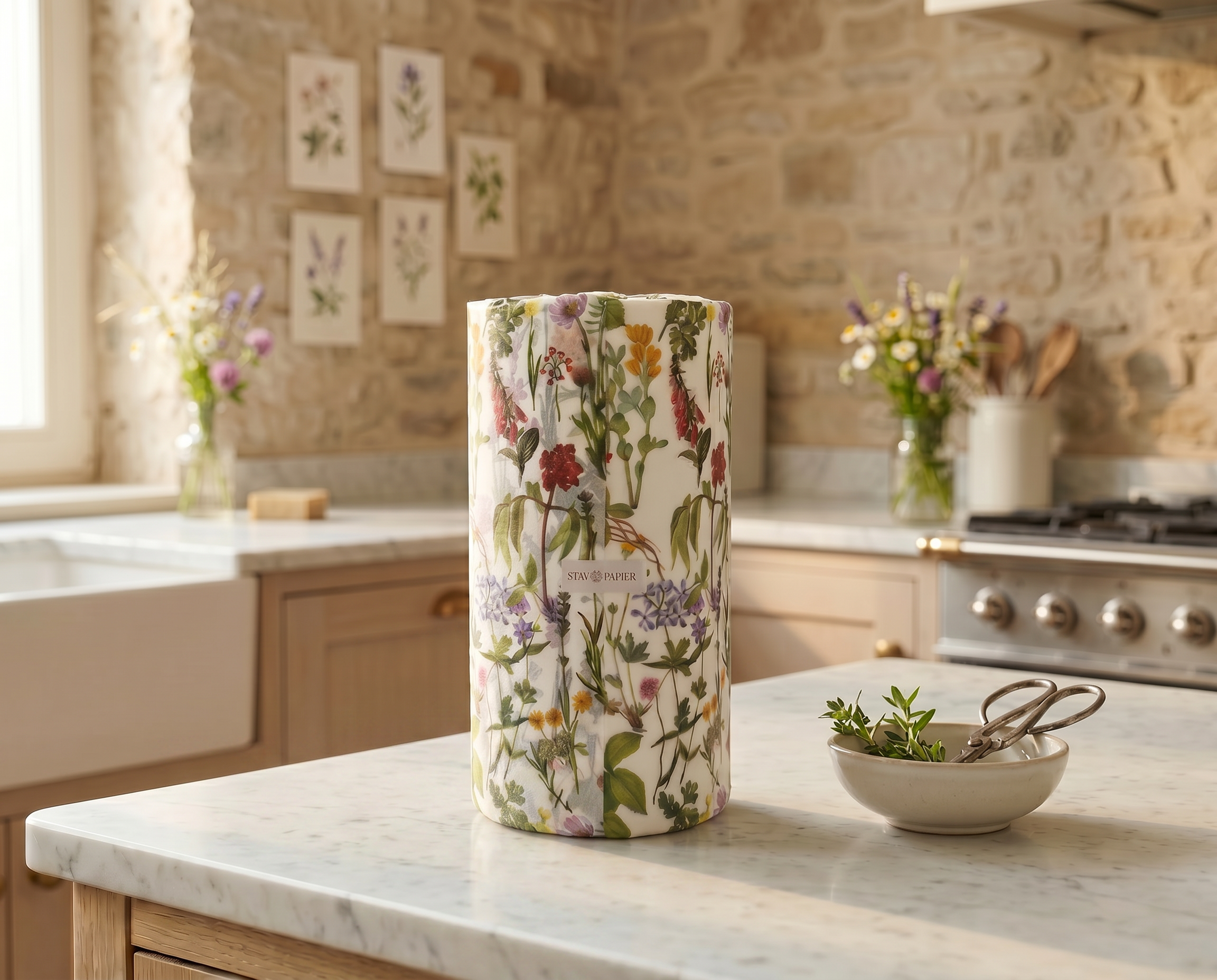 Decorative tissue wrapped roll of Stay Papier paper towels with wildflower floral design on a marble stone kitchen counter.